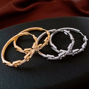 Macro shot of 18K gold and silver plated hoop earrings with sparkling zircon paving