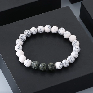 Detailed view of 8mm white turquoise and green goldstone beads on a premium black box
