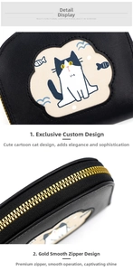 Close-up of black pebble leather purse with cartoon cat embroidery and gold zipper detail