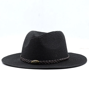 Detail of black straw fedora showing fine weave texture and bronze bull logo on brown band