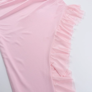 Nahaufnahme der zartrosa Rüschenkanten und des mehrlagigen Netzgewebes am langen Kleid