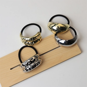 Close-up of minimalist gold and silver alloy hair ties with hammered and smooth textures