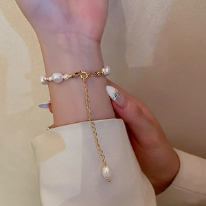 Detail of adjustable baroque freshwater pearl bracelet with gold lobster clasp on wrist