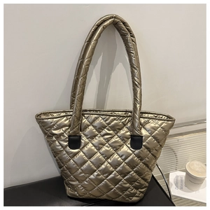Détail d'un grand sac cabas matelassé or champagne avec surpiqûres en losanges sur cuir noir