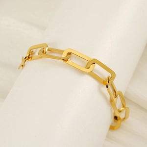 Bracelet chaîne trombone en or 18k poli présenté sur un support cylindrique blanc