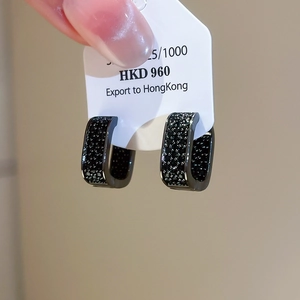 Close-up of U-shaped black zircon micro-pave earrings on an S925 silver jewelry card