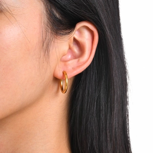 Close-up of minimalist 18k gold plated stainless steel hoop earring on a model