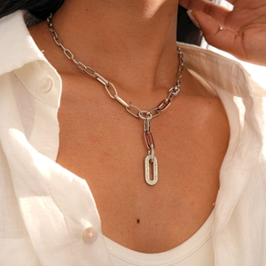 Close-up of silver paperclip chain necklace with sparkling pavé rhinestone oval link