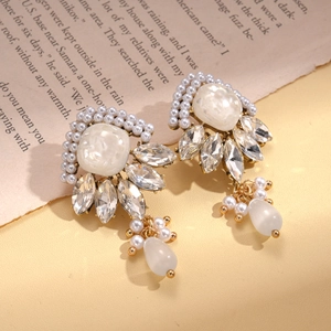 Detailed shot of resin pearl earrings with marquise crystals on vintage book paper