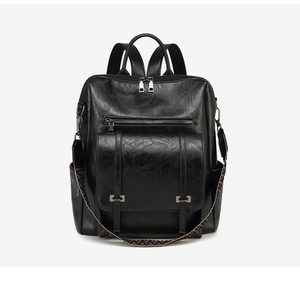 Detail view of the black PU leather backpack with a decorative ethnic woven strap and hardware