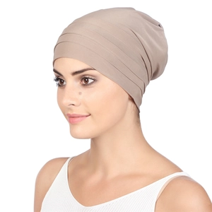 Detail view of khaki pleated turban hat with elastic fabric texture on female model