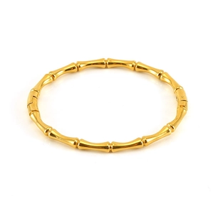 Detailed close-up of gold bamboo-style stainless steel bangle with high-gloss metallic finish