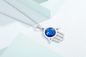 Vue détaillée du collier main de Fatma avec cristal bleu central et petits diamants