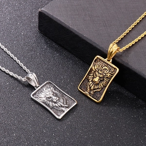 Détail de pendentifs tête de lion en or et argent avec des chaînes torsadées