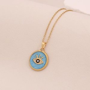 Détail du pendentif œil doré avec émail bleu sur une chaîne à maillons fins