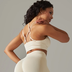 Detail of cream seamless ribbed sports bra with criss-cross back straps and yoga leggings