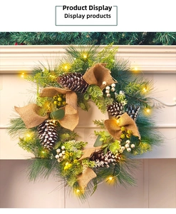Close-up of lighted Christmas wreath with pine cones, berries and a burlap bow on a mantel