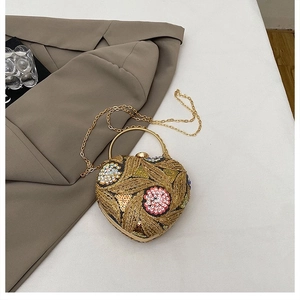 Detailed embroidery and sequins on heart-shaped clutch bag with golden metal ring handle