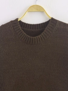 Close-up of soft fuzzy knit texture and ribbed crew neck on a dark brown sweater