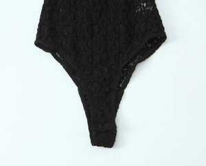 Close-up of black floral lace bodysuit showing high-cut leg and intricate fabric detail