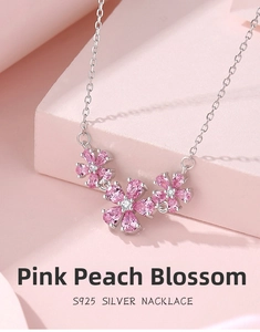 Macro shot of S925 sterling silver necklace featuring pink peach blossom flower charms