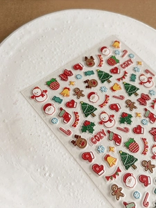 Macro shot of 3D embossed Christmas nail art stickers with Santa and reindeer motifs