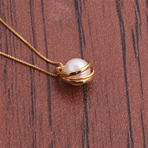 Irregular geometric necklace with a gold cage pendant holding a white pearl on a red surface