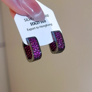 Macro shot of U-shaped gunmetal earrings featuring densely paved purple zircons
