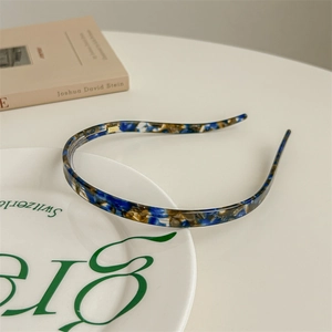 Detail of thin tortoiseshell acetate headband with anti-slip teeth on a white plate
