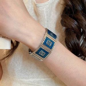 Detailed macro view of wide silver-plated square bracelet with deep blue enamel inlay