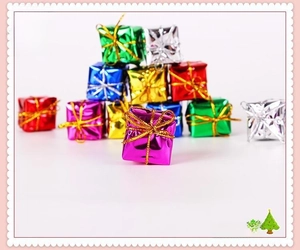 Close-up of colorful metallic Christmas tree gift box ornaments with gold ribbons