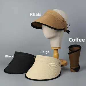 Detail view of foldable straw sun visors with metal logo and storage buckle closure