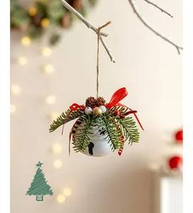 Weiße Weihnachtsglocke mit roter Schleife und Tannenzapfen an einem rustikalen Zweig