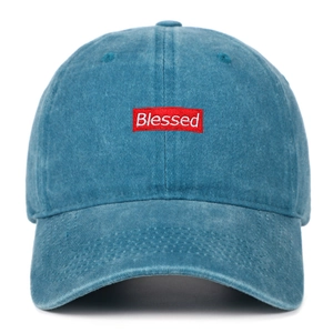 Close-up of Blessed embroidery and washed denim texture on blue cotton baseball cap