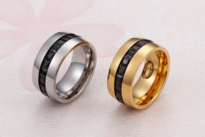 Macro view of gold and silver wide band rings with black geometric step pattern