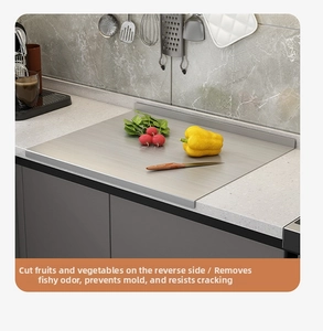 L-shaped edge of stainless steel cutting board fitting perfectly over a kitchen counter