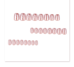 Detail of 24 press-on nails set with pink base, white stripes, and polka dot patterns