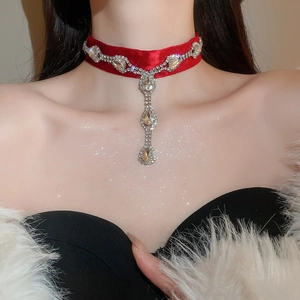Détail d'un ras-du-cou en velours rouge orné de cristaux scintillants sur le cou du mannequin