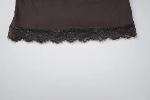 Vue détaillée de l'ourlet en satin chocolat avec bordure en dentelle cil et fini lisse