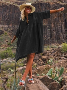 Detail of loose black polo collar shirt dress with buttons in an outdoor vacation setting