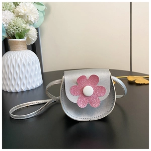 Close-up of kids silver purse featuring a pink sequin flower decoration and metal strap