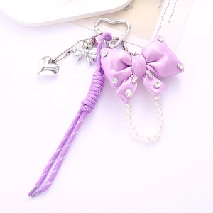 Detailed shot of purple satin bow charm with rhinestones and pearl bead chain accent