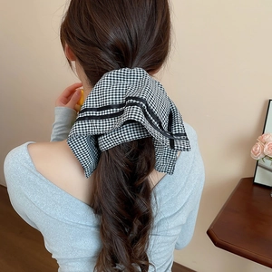 Detailed back view of a black and white checkered hair scarf tied on a ponytail
