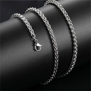 Macro detail of vintage sterling silver lobster clasp and braided chain texture on necklace