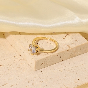 Adjustable 18K gold plated ring with round cubic zirconia on a stone and silk background