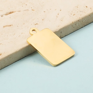 Close-up of a polished golden stainless steel rectangular pendant with a small hole