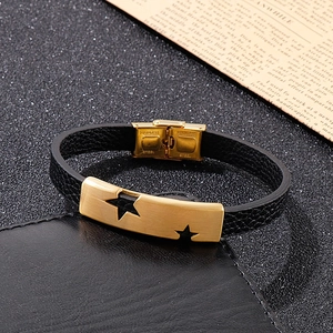 Close-up of star cutout on gold stainless steel plate with black leather strap