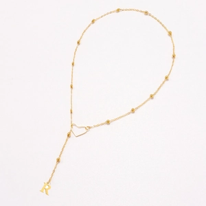Golden heart necklace with letter R pendant on a bead chain with a minimalist style