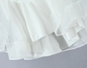 Gros plan des volants blancs et du tissu en tulle sur une robe dos nu de style français