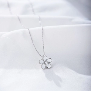 Macro detail of S925 silver floral pendant with white petals and a central zircon stone